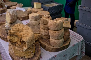 Çeşitli yuvarlak peynirlerin sunumu. Açık hava sokak panayırı. Ukrayna.
