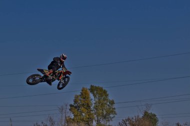 Kyiv, Ukrayna - 9 Ekim 2021: Mavi gökyüzünün arka planına karşı motorsikletle aşırı atlama. Aktif aşırı dinlenme. Yüksek uçan motosiklet yarışçısı.