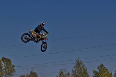 Kyiv, Ukrayna - 9 Ekim 2021: Mavi gökyüzünün arka planına karşı motorsikletle aşırı atlama. Aktif aşırı dinlenme. Yüksek uçan motosiklet yarışçısı.