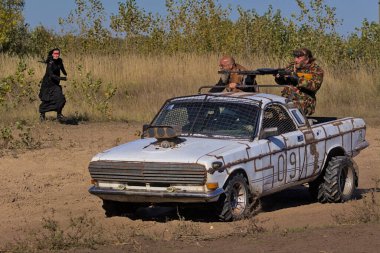 Kyiv Ukrayna - 9 Ekim 2021: Tanımlanamayan yaşlı sakallı adamlar eşsiz bir yolcu vagonunda duruyorlar. Kamyonetin çatısına otomatik bir makine yerleştiriliyor. Tozlu off-road.