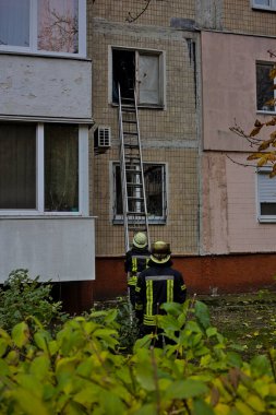 Kyiv, Ukrayna - 30 Ekim 2021: Bir itfaiyeci yangını söndürmek için konut binasının ikinci katına çıkıyor. İtfaiyeci yangın koruma giysisi giymiş..