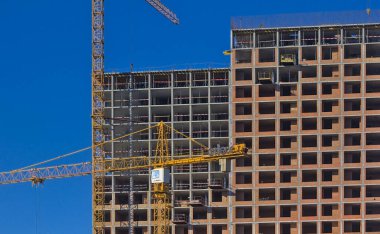 Kyiv, Ukrayna - 25 Ekim 2021: Yüksek katlı bir konut kompleksinin modern yapısının soyut bir parçası. Modern apartman inşaatı. Mavi gökyüzü.