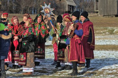 Kyiv, Ukrayna - 7 Ocak 2022: Ortodoks Noel kutlamaları sırasında Ukraynalılar ulusal kostüm giydiler. Ukrayna 'da Noel doğumu sahnesi. Eski kış gelenekleri.