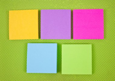 coloridas notas adhesivas sobre fondo de tela verde.