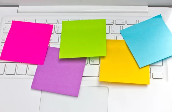 Colorido notas pegajosas post no teclado do laptop branco — Fotografia de Stock