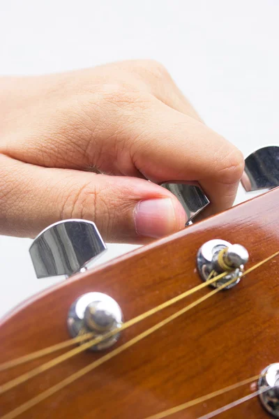 Hand tuning a guitar from headstock isolated on white background — Stock Photo, Image