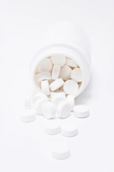 Weiße Medikamente strömen aus Container. — Stockfoto