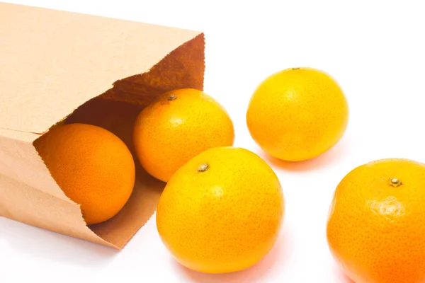 Kağıt torba, beyaz zemin üzerine izole dan düşen portakal. — Stok fotoğraf