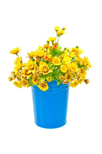 Plastové žluté květy s kovovou modrou vázu pověsit na zeď. — Stock fotografie
