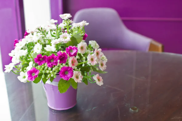 Mooie kunststof bloemen in metalen vaas met kopie ruimte. — Stockfoto