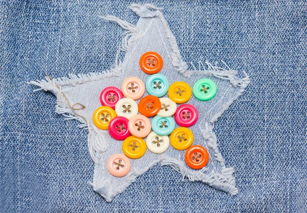 Multicolored buttons on demin starred shaped. — Stock Photo, Image