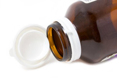 Beyaz arka plan üzerine açık kap ile boş ilaç şişesi.