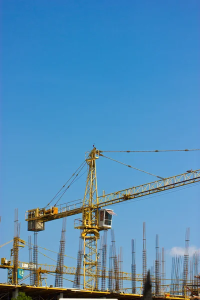 Site de construction avec grue isolée sur ciel bleu . — Photo