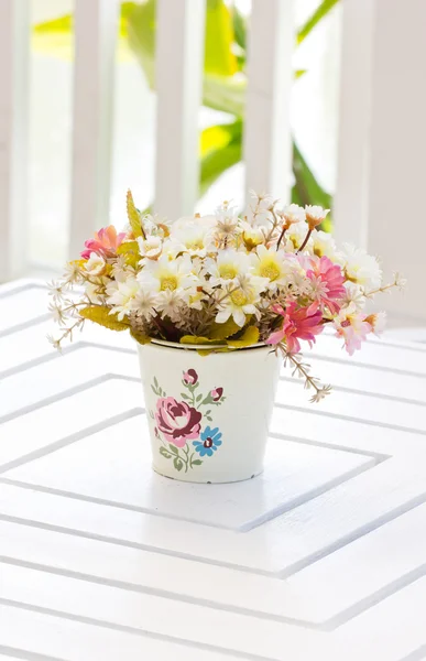 Beautiful plastic flowers in metal vase. — Stock Photo, Image