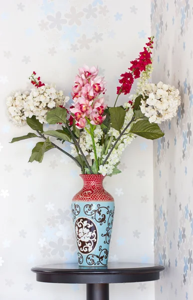 Plastic flowers with ancient vase. — Stock Photo, Image