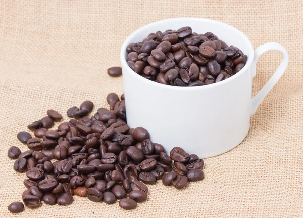Kopje koffie bonen vol met rouwgewaad. — Stockfoto