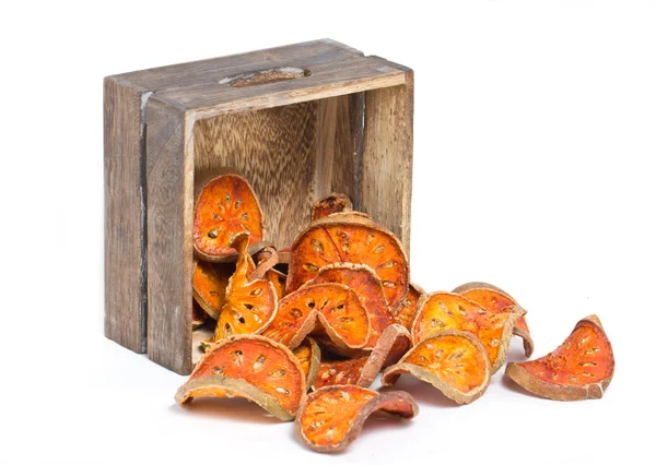 Slices of dried bael fruit with wooden box. — Stock Photo, Image