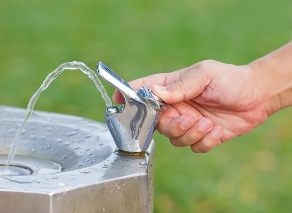 La mano enciende el grifo de agua potable —  Fotos de Stock