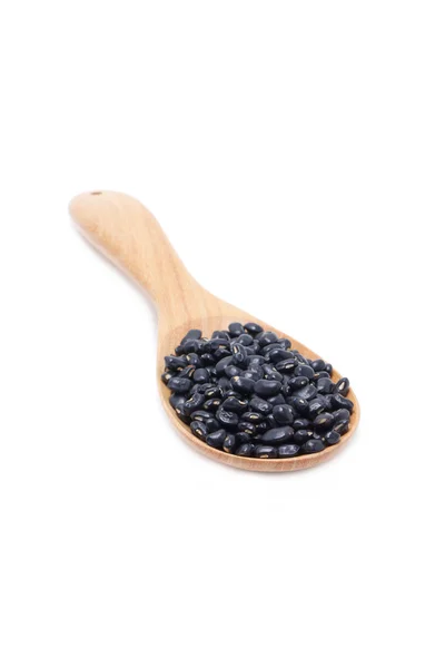 Black beans with wooden spoon — Stock Photo, Image