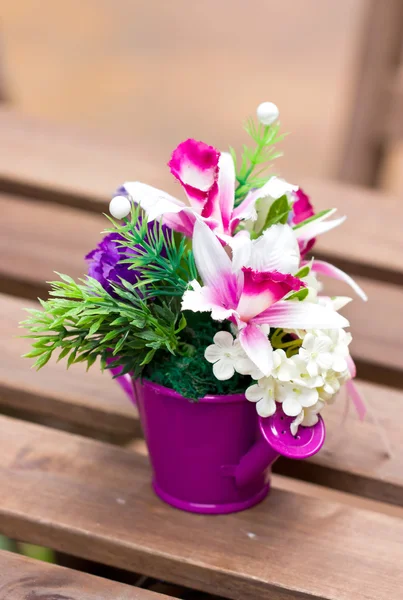 Fleurs artificielles en vase métallique coloré . — Photo