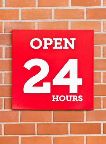 24 hours red signboard on brick background. — Stock Photo, Image