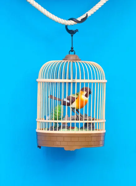 Birdcage with artificial colorful bird — Stock Photo, Image