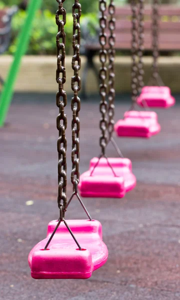 Pink swing in playground. — Stock Photo, Image