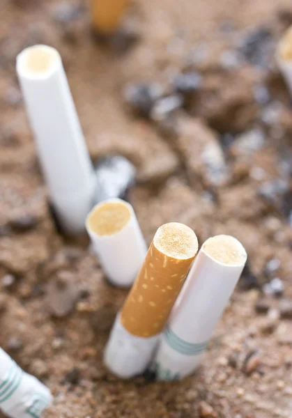 Smoked cigarette in sand. — Stock Photo, Image