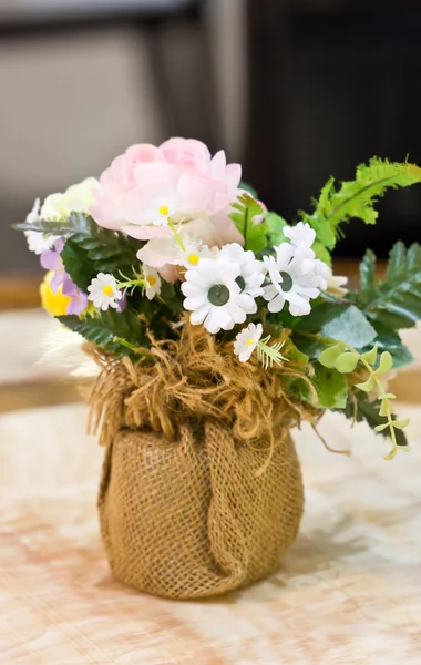 Искусственные цветы в вазе из мешковины . — стоковое фото