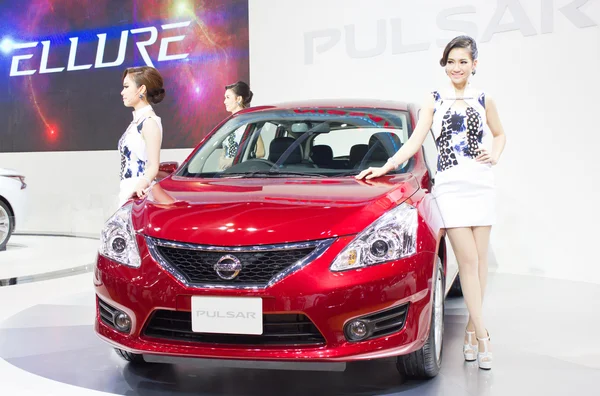 Unidentified models with Nissan Pulsar car — Stock Photo, Image