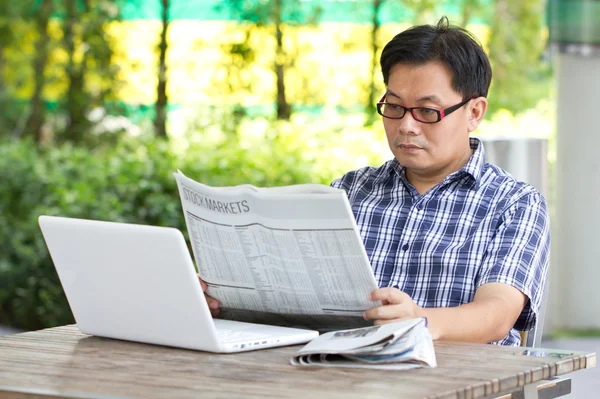 Hombre asiático leyendo el periódico financiero —  Fotos de Stock