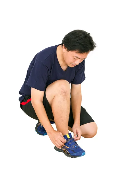 Asiatischer Mann bindet Sportschuhe. — Stockfoto