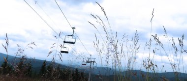 Cableway yerden, mavi gökyüzüne karşı karanlık bir siluet olarak ele geçirildi. Dev Dağlar (Krkonose), Çek Cumhuriyeti, Bohemya Bölgesi.