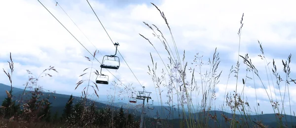 Cableway yerden, mavi gökyüzüne karşı karanlık bir siluet olarak ele geçirildi. Dev Dağlar (Krkonose), Çek Cumhuriyeti, Bohemya Bölgesi.