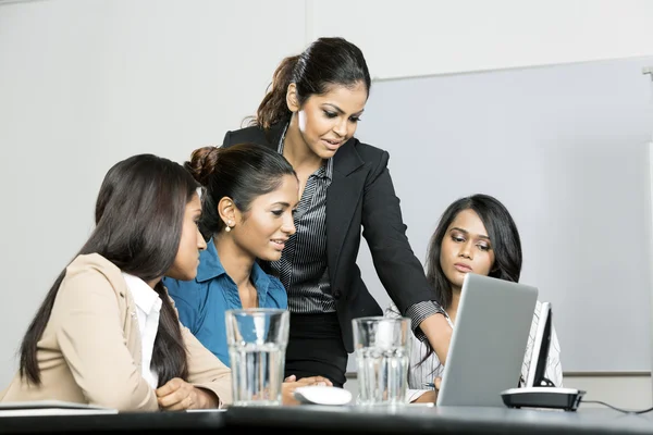 Indian colleagues working around a laptop