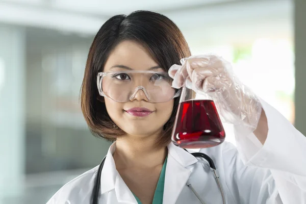 Chinese Female scientist analyzing a solution.