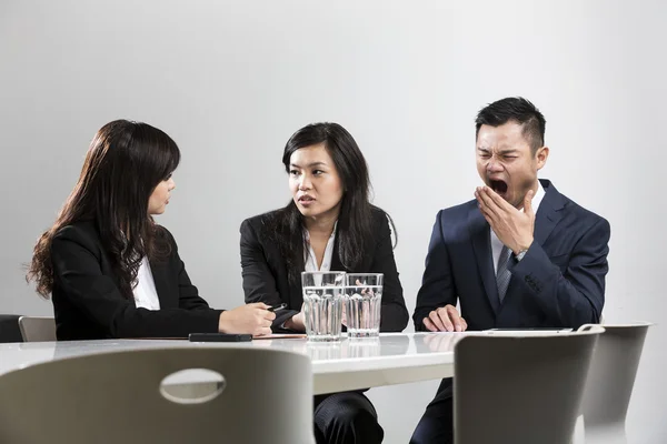 Chinese businessman yawning during business meeting