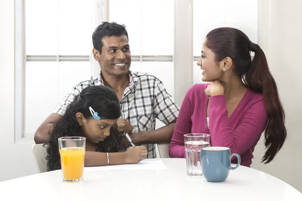 Indian family helping their child with her study work