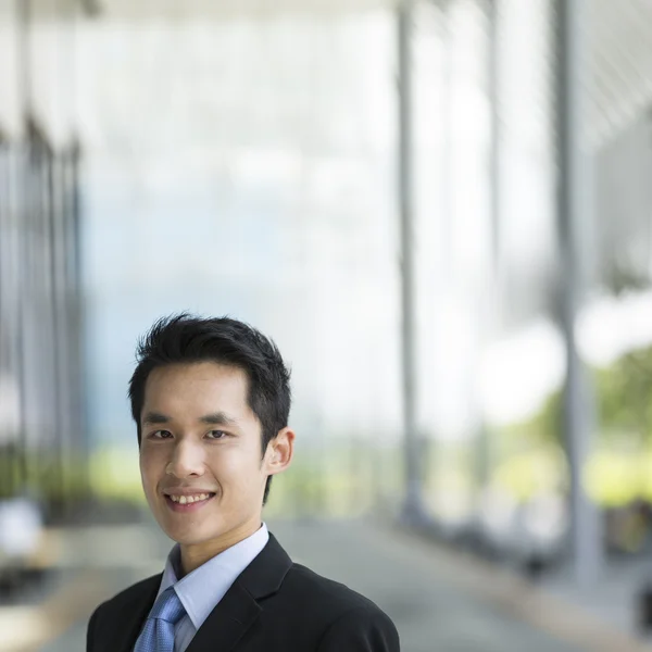 happy young Chinese business man in modern city