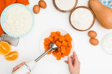 Adım adım zebra şeklinde kabak kremalı güveç tarifi portakallı turuncu sonbahar turtası. Kabak turtası üst görünümü için malzemeler karıştırılıyor.