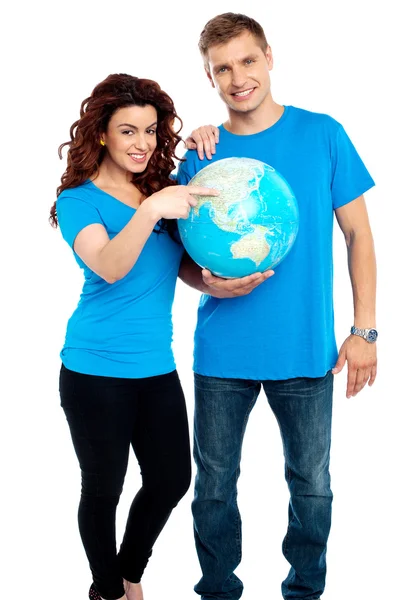 Couple posing for a picture with globe in hand — Stock Photo, Image