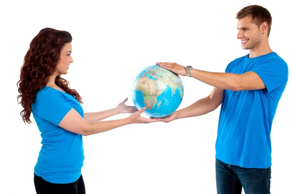Causal young couple holding globe together — Stock Photo, Image