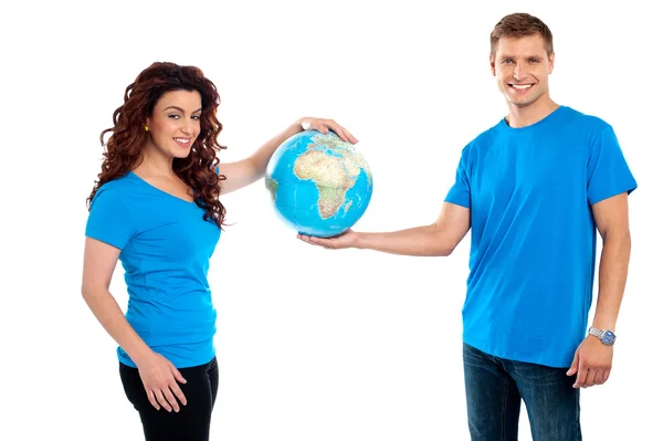 Attractive young couple holding a globe together — Stock Photo, Image