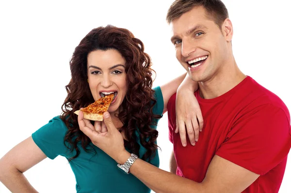 Boyfriend making her girl eat hot pizza piece — Stock Photo, Image