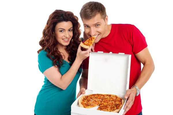 Pretty woman making her boyfriend end pizza piece — Stock Photo, Image