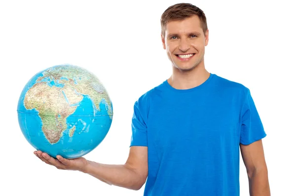 Aantrekkelijke jonge man met globe in zijn hand — Stockfoto