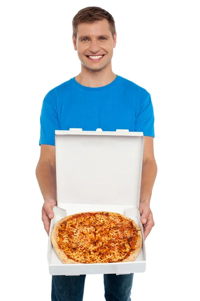 Sorrindo homem oferecendo pizza para você — Fotografia de Stock