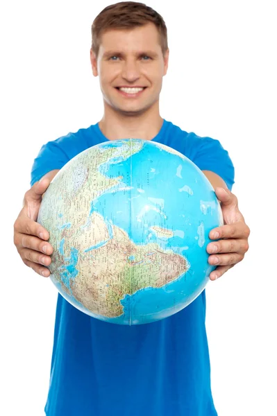 Casual jonge kerel voorstellende globe — Stockfoto