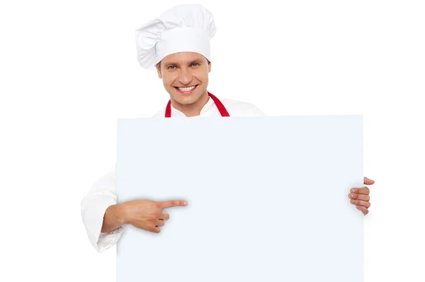 Шеф-повар указывает на чистый белый рекламный щит — стоковое фото