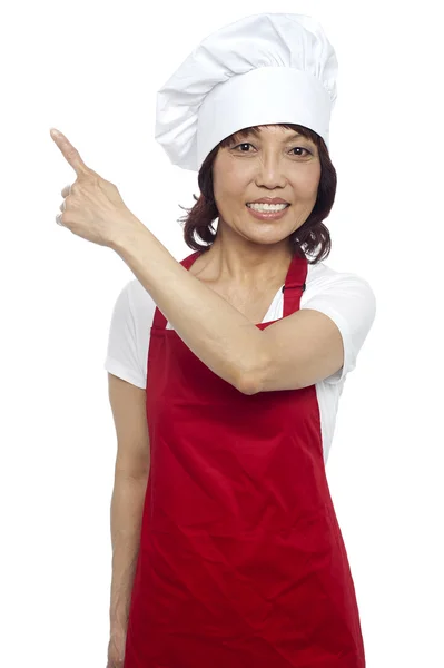 Жіночий шеф-кухар у формі вказує геть. Копіювати концепцію простору — стокове фото